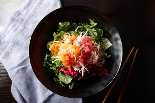 Sashimi salad on black plate - Australian Stock Image