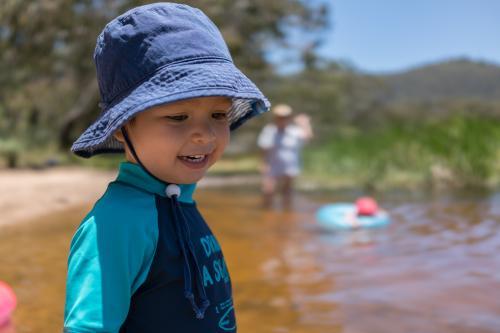 3 year old mixed race boy swims and plays in a river - Australian Stock Image