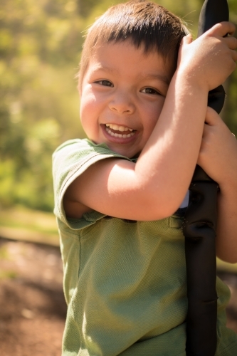 4 year old mixed race boy plays on a flying fox - Australian Stock Image