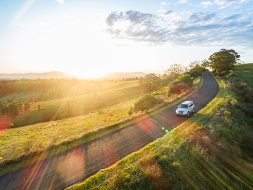 4x4 car driving on country road trip adventure on narrow road at sunset - Australian Stock Image