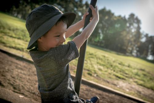 5 year old mixed race boy plays outdoors in a playground - Australian Stock Image