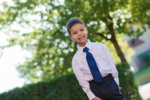 5 year old mixed race boy wearing his school uniform on his first day of school - Australian Stock Image