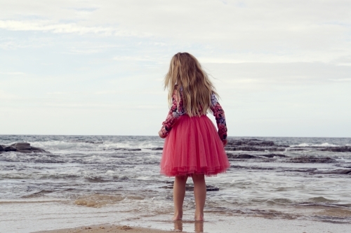 5 year old on beach looking out to sea - Australian Stock Image