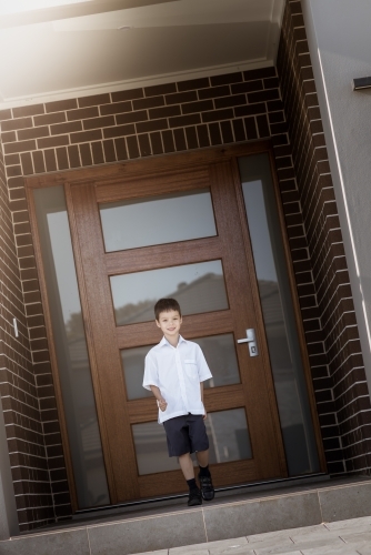 6 year old mixed race boy leaves home for his first day of school - Australian Stock Image