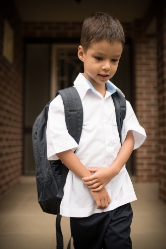 6 year old mixed race boy leaves home for his first day of school - Australian Stock Image