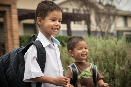 6 year old mixed race boy leaves home for his first day of school - Australian Stock Image