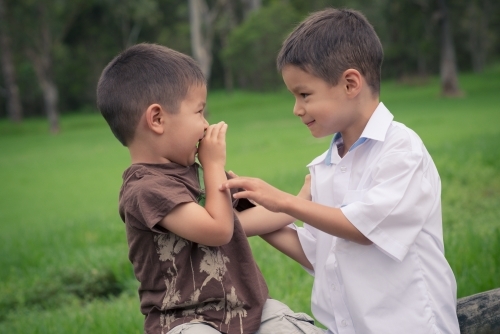 6 year old mixed race boy plays with his brother before leaving on his first day of school - Australian Stock Image