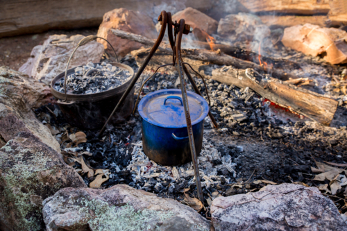 A bill can and a camp oven at a campfire - Australian Stock Image