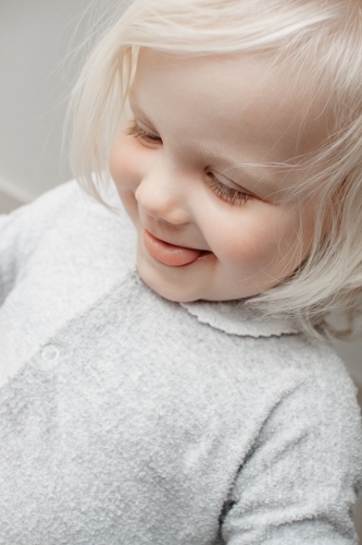 A blonde haired blue eyed two year old caucasian girl wearing a traditional Australian grow suit - Australian Stock Image