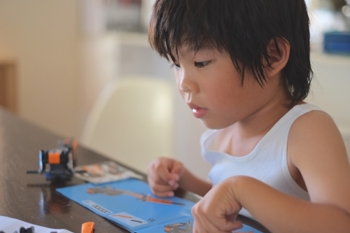 a boy, building a Lego formula race car - Australian Stock Image