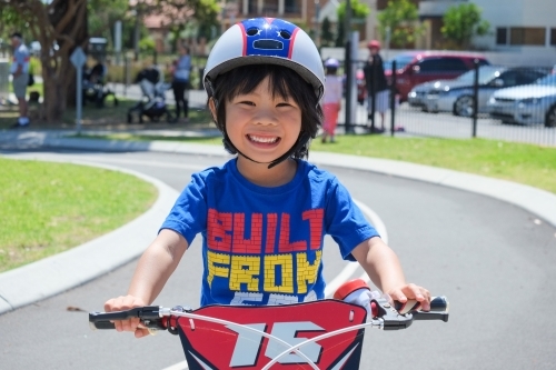 a boy happily riding his bike on a bike track - Australian Stock Image