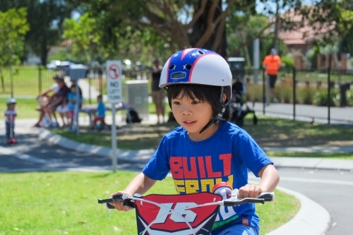 a boy happily riding his bike on a bike track - Australian Stock Image