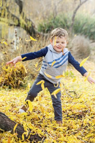 A boy playing in Autumn leaves