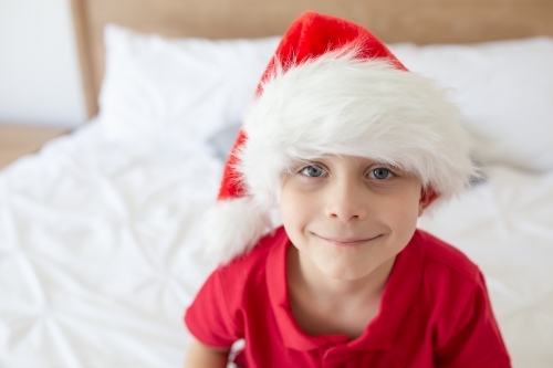 A boy wearing a red shirt and Santa hat at christmas time in Australia - Australian Stock Image