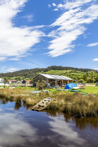 A building and boats on a river bank - Australian Stock Image