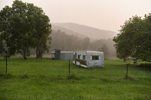 A camping van in the middle of a farm paddock