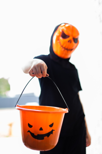 a child trick or treating in costume with a full bucket - Australian Stock Image