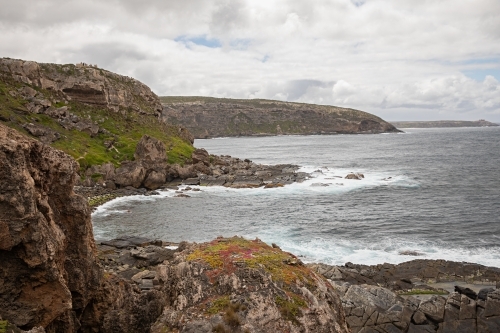 A coastal cliff with ragged waters and jagged rocks - Australian Stock Image