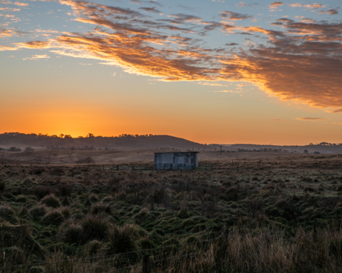 A colourful dawn sky over a country field - Australian Stock Image
