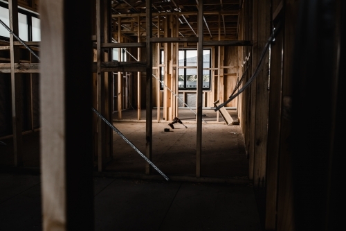 A construction site of a house being built with exposed wires and wooden beams - Australian Stock Image