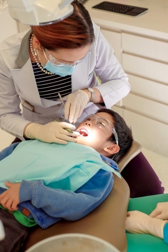 A dentist checking a kid's teeth - Australian Stock Image