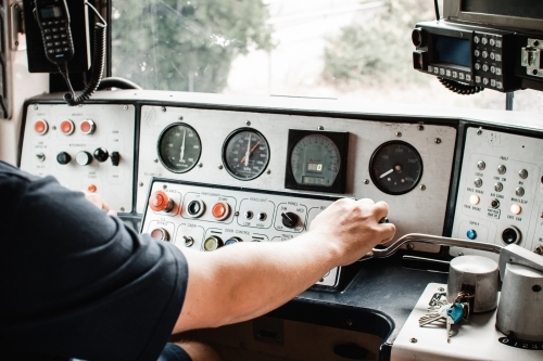 A electric train in Melbourne Australia, inside controls being driven by a train driver