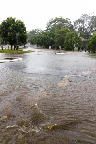 A flooded suburban street in suburban Brisbane during a major rain event - Australian Stock Image