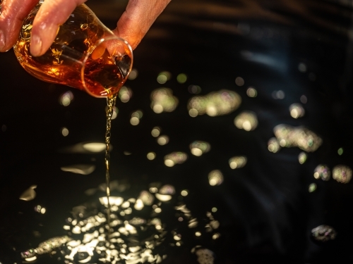 A glass of whisky poured into a whisky still - Australian Stock Image