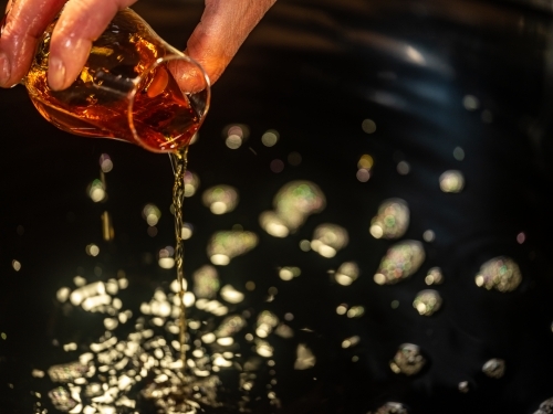 A glass of whisky poured into a whisky still - Australian Stock Image