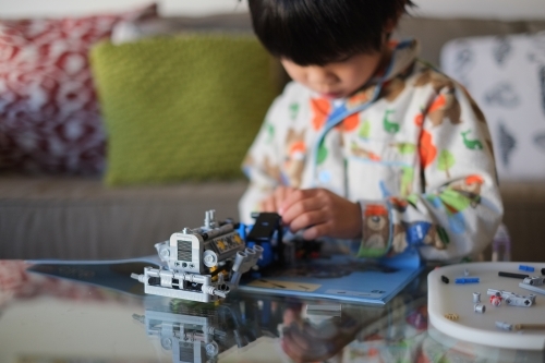 a kid building a Lego piece - Australian Stock Image