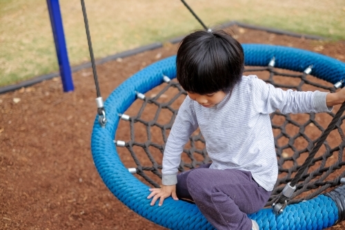 A kid swinging at a playground