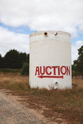 A large cylindrical tank with an "Auction" sign direction - Australian Stock Image