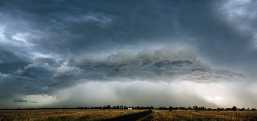 A large, ominous storm cloud formation over an expansive landscape. - Australian Stock Image