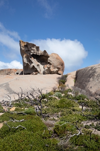 A large rock formation weathered by time like stone sculpture in sunlight - Australian Stock Image