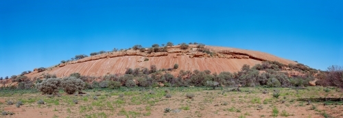 A large, rounded hill with a smooth surface and trees - Australian Stock Image