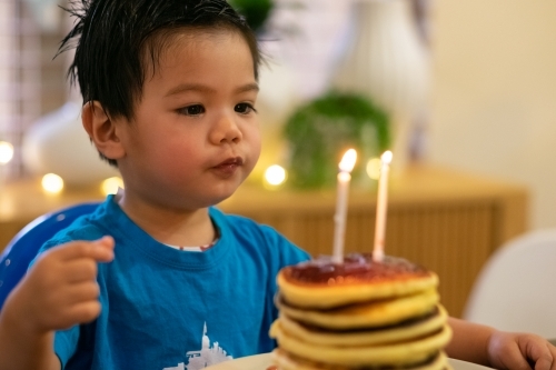 A lucky kid getting a hotcake stack on his second birthday - Australian Stock Image