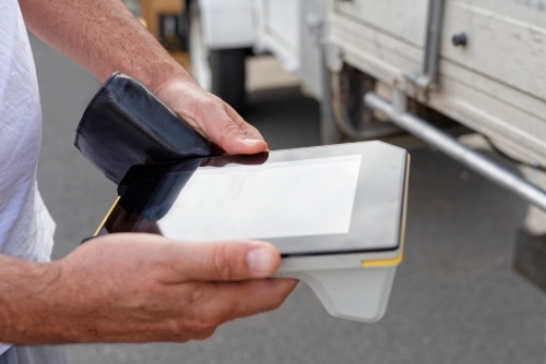 A man holding an electronic eftpos terminal in his hands - Australian Stock Image