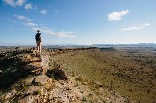 A man in hiking gear overlooking the rugged landscape of the Flinders Ranges - Australian Stock Image