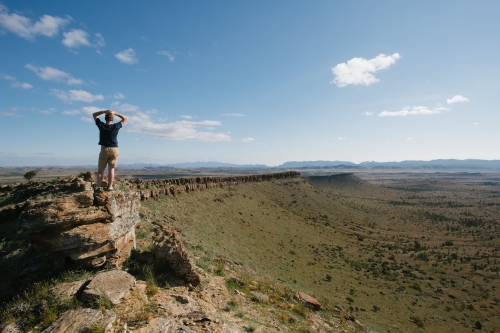 A man with hands on head overlooking the rugged landscape of the Flinders Ranges