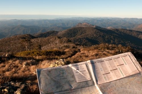 A map being held with mountain ranges in the background.