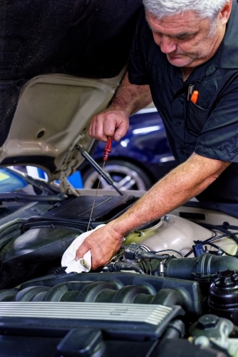 A mechanic servicing a luxury car in his workshop on the Gold Coast - Australian Stock Image