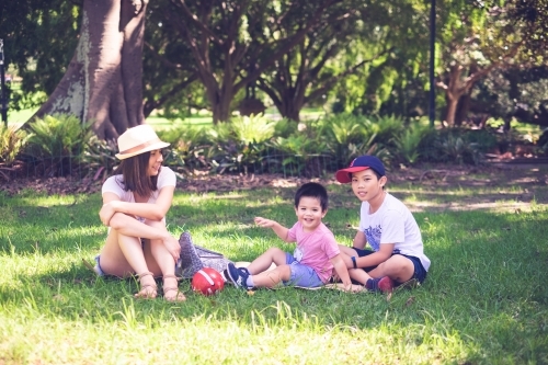 A mum and her kids enjoying a sunny day at the park - Australian Stock Image