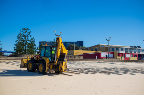 A sand digger truck plowing the beach at Maroubra - Australian Stock Image