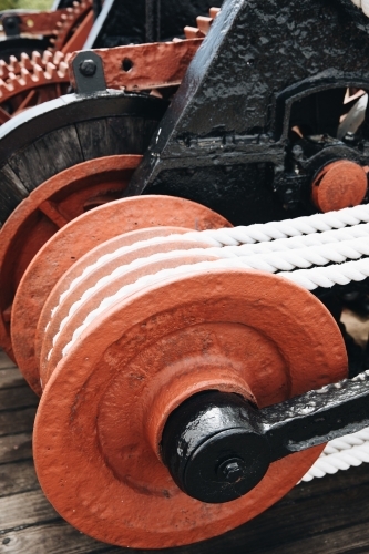 A series of white ropes wound around a large, red wheel or pulley at Old Whaling Station - Australian Stock Image