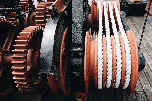 A series of white ropes wound around a large, red wheel or pulley at Old Whaling Station - Australian Stock Image