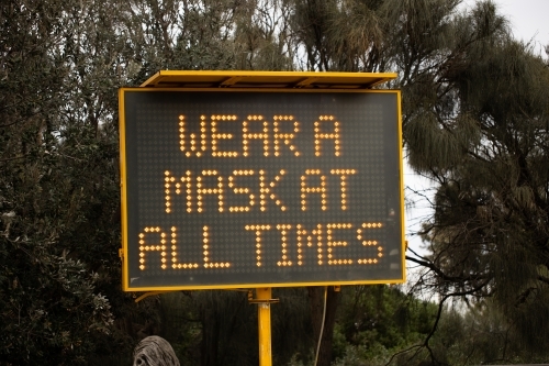 A sign during the COVID-19 corona virus pandemic which says 'wear a mask at all times' - Australian Stock Image