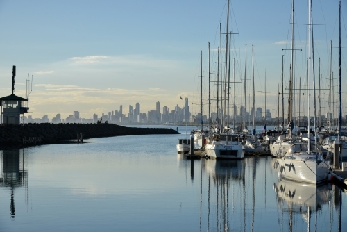 A small harbor full of yachts with the city skyline in the background - Australian Stock Image