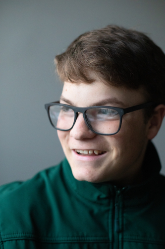 A teenage boy with black glasses smiling - Australian Stock Image