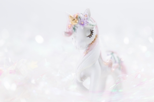 A unicorn figurine with a whimsical background. - Australian Stock Image