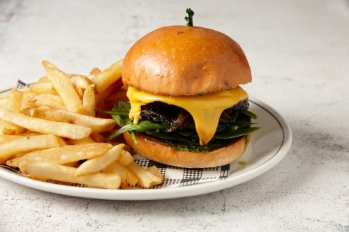 A vegetarian mushroom burger served with chips - Australian Stock Image